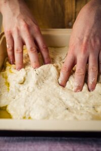 person holding white dough on white table